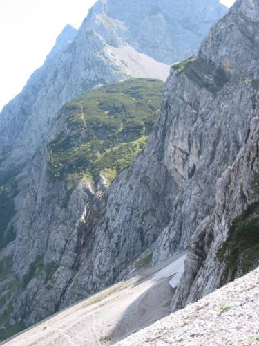 Blick auf den Bäralplsattel. In dem tiefen Einschnitt entspringt ein Wasserfall, während der Weg auf dem breiten grünen Absatz rechts oben verläuft. (IMG_3497)